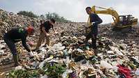 Männer arbeiten auf einer Mülldeponie