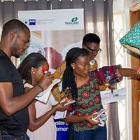 Ghanaische Frauen und Männer arbeiten an einer Pinnwand