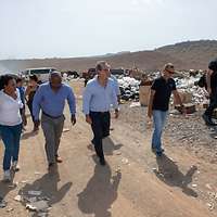 Mehrere Männer und eine Frau begehen eine Müllhalde